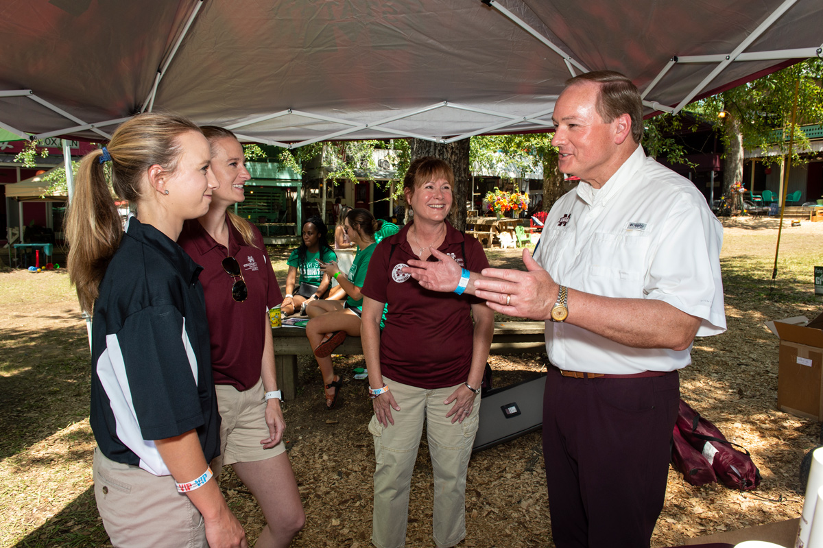 MSU President Mark E. Keenum visits with university administrators attending Meridian Day at the Neshoba County Fair.