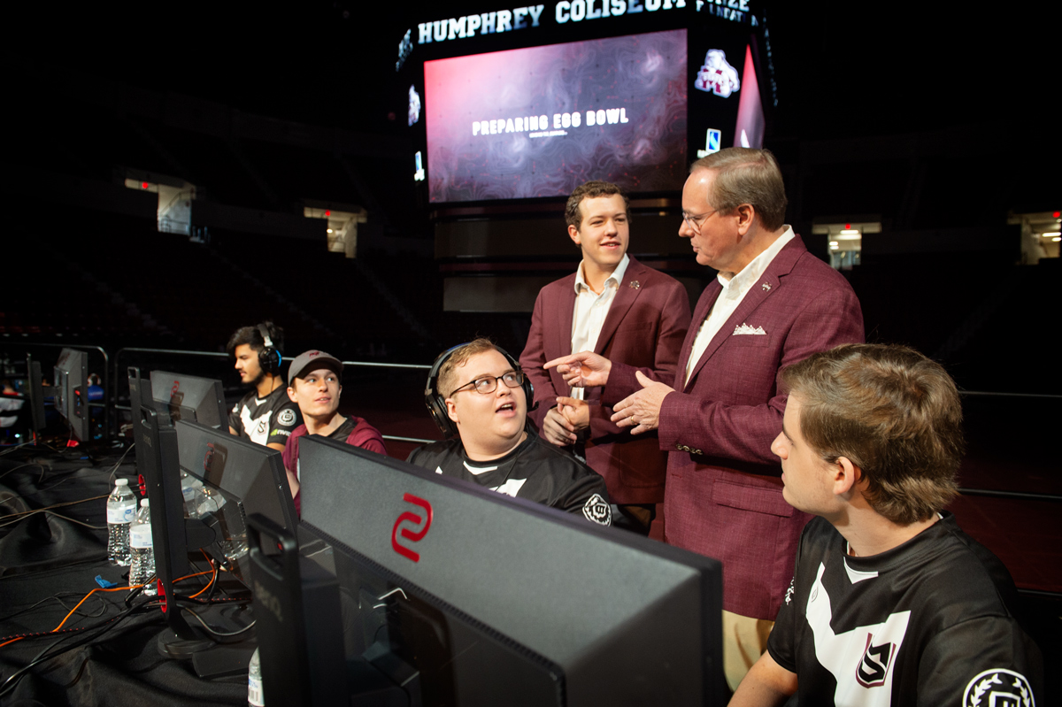 With the esports Egg Bowl scoreboard behind them, President Keenum and SA President Jake Manning greet MSU gamers on the stage.