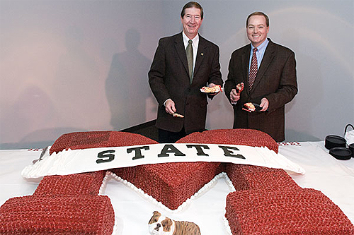 Tommy Tomlinson (l), Cadence Bank president, and Mississippi State President Mark Keenum prepare to serve first slices from the university's 131st year birthday cake.