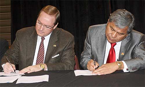 President Keenum signs a Memorandum of Understanding along with Mississippi Band of Choctaw Indians Miko (Leader) Beasley Denson Friday at the Choctaw Central High School gymnasium.