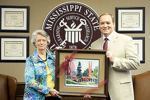 Nancy Bearden receives a framed Chapel of Memories print from President Mark Keenum, who met with her in appreciation of her commitment to MSU spanning nearly 51 years.