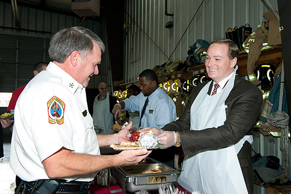 MSU President Mark Keenum serves food to Starkville Fire Chief Rodger Mann at the Lampkin Street Fire Station.