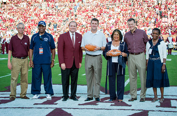Dr. Keenum and Scott Stricklin present footballs to Hank Bounds, Mississippi Commissioner of Higher Education, and Carolyn Meyers, Jackson State University president at halftime of the MSU/JSU football game.