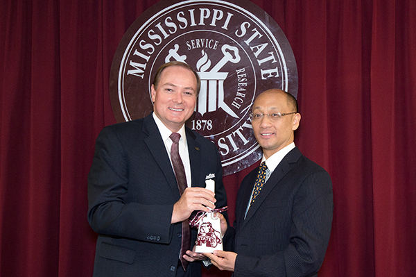 MSU President Mark E. Keenum presents a cowbell to President Lusheng Huang of Jiangxi Agricultural University in Nanchang, China.