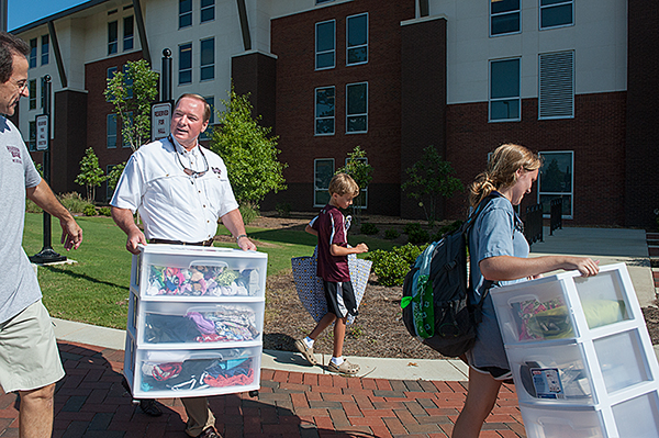 MSU President Mark E. Keenum and his son, Rett, help a freshman as she moves into Magnolia Hall Saturday.