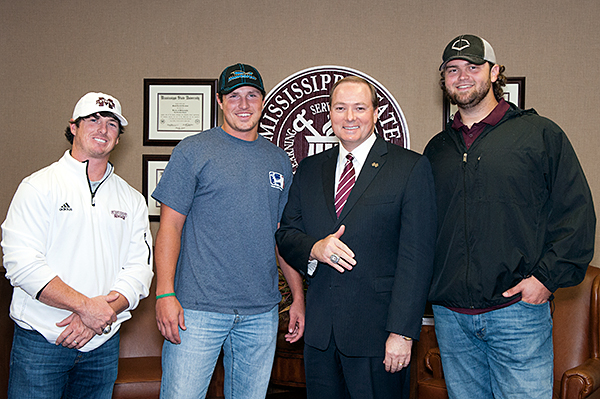 Director of Baseball operations Tyler Bratton, left, and players Hunter Renfroe and Wes Rea present MSU President Mark E. Keenum with a College World Series ring.