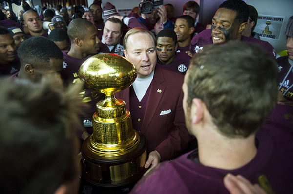 In the wild post-game locker room scene, MSU President Mark E. Keenum congratulates Head Coach Dan Mullen and the MSU Bulldogs on their thrilling 17-10 win over the Ole Miss Rebels in the 2013 Egg Bowl.