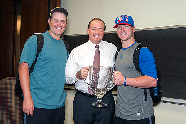 Diamond Dawgs pitcher Trevor Fitts, a junior from Helena, Ala., left, and catcher Gavin Collins, a freshman from Lake Forest, Calif., right, president MSU President Mark E. Keenum with the Governor's Cup Trophy.