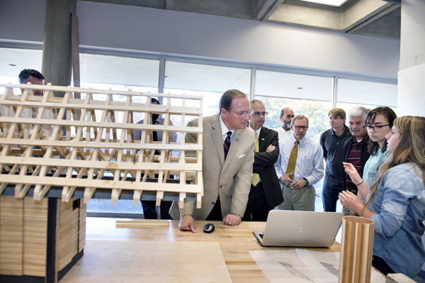 MSU President Mark E. Keenum, center, listens as a second-year architecture student explains the service project she and her classmates are completing.