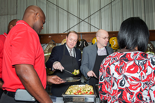 Mississippi State President Mark E. Keenum, center left, and Starkville Mayor Parker Wiseman serve Starkville firefighters and first responders at the annual Thanksgiving celebration at Fire Station One.