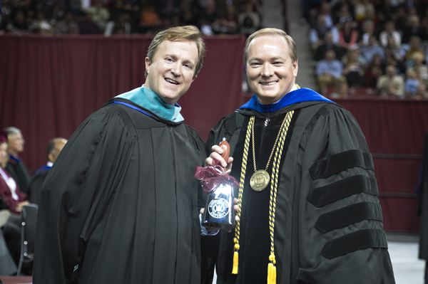 MSU President Mark E. Keenum, right, presents commencement speaker Haley R. Fisackerly with a chrome cowbell during Saturday’s graduation activities at Humphrey Coliseum.