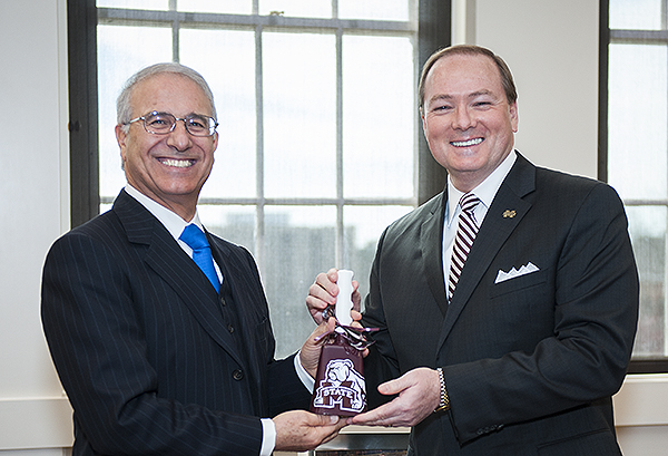 Moroccan Ambassador Rachad Bouhlal, left, accepts a complementary cowbell from Mississippi State University President Mark E. Keenum.
