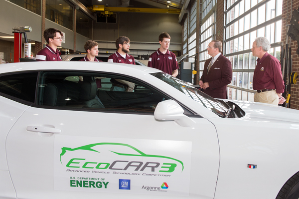MSU President Mark E. Keenum, second from right, talks with the university’s EcoCAR3 team as they prepare for upcoming national competition against 15 other universities.