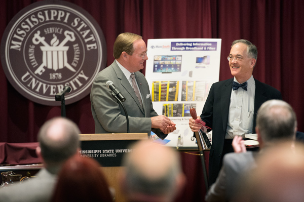 MSU President Mark E. Keenum, left, presents a cowbell to John Robinson Block, publisher and editor-in-chief of the Pittsburgh Post-Gazette and Toledo Blade.