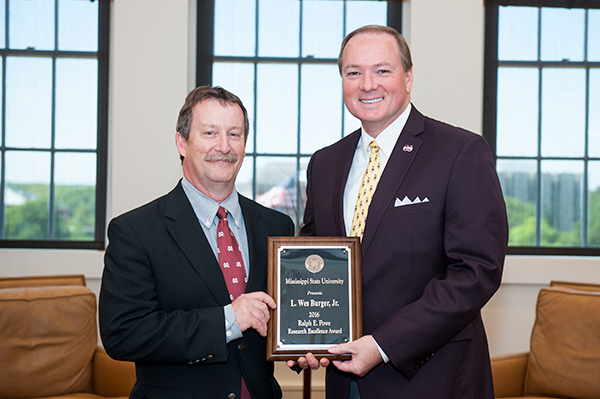 Wes Burger, left, the 2016 Ralph E. Powe Research Excellence Award honoree, is congratulated by MSU President Mark E. Keenum.
