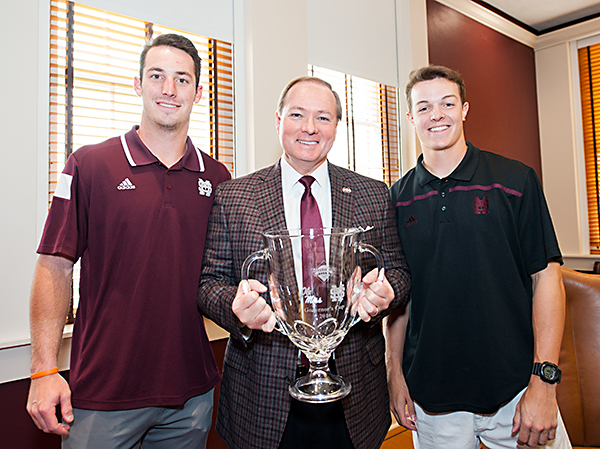 Mississippi State sophomore baseball players Brent Rooker (left) and Jacob Billingsley (right) presented the Governor’s Cup to university President Mark E. Keenum.
