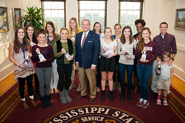 MSU President Mark E. Keenum poses with members of the MSU Cross Country Team and Coach Houston Franks.