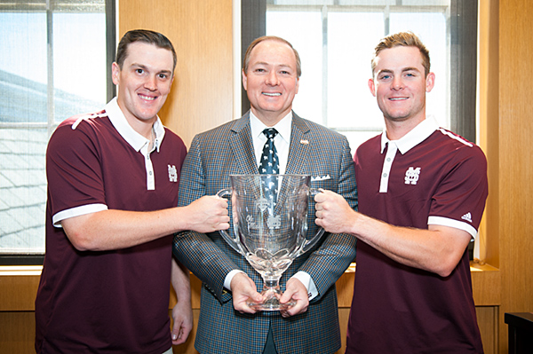Mississippi State University baseball players Josh Lovelady (left) and Cody Brown (right) present the Governor’s Cup trophy to MSU President Mark E. Keenum on May 8.