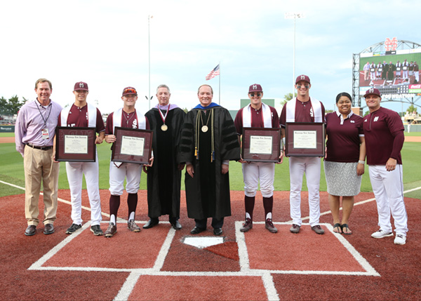 Mississippi State President Mark E. Keenum, center, held a special graduation ceremony at Dudy Noble Field May 18 to recognize senior baseball players who were competing at Texas A&M during MSU’s Spring Commencement.