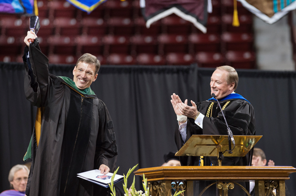 Dr. Allen K. Sills Jr., left, rings a cowbell presented by MSU President Mark E. Keenum, right, after the morning commencement address Dec.