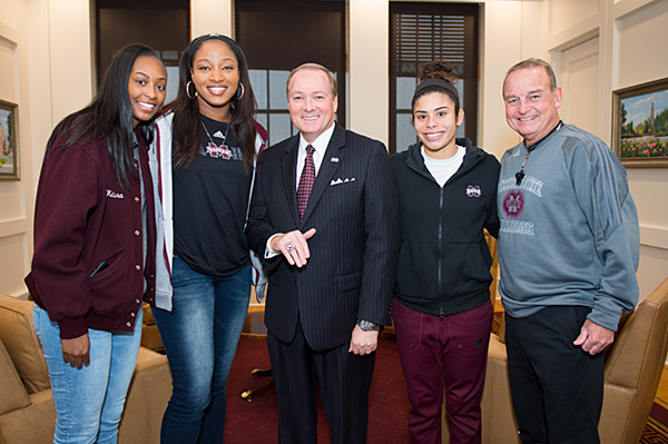 Former Mississippi State women’s basketball players, from left, Ketara Chapel, Chinwe Okorie and Dominque Dillingham, along with head coach Vic Schaefer, present MSU President Mark E. Keenum with a 2017 National Finalist ring.