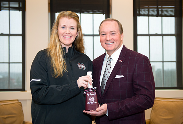 Mississippi State University President Mark E. Keenum presents a cowbell to Julie Darty, MSU’s new women’s head volleyball coach.