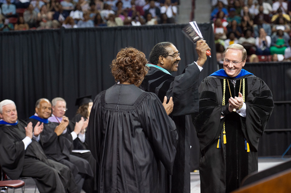 Robert G. Clark Jr., former Speaker Pro Tempore of the Mississippi House of Representatives, rings a chrome cowbell after being presented with an honorary Doctor of Public Service degree during Mississippi State’s spring 2018 commencement ceremonies.