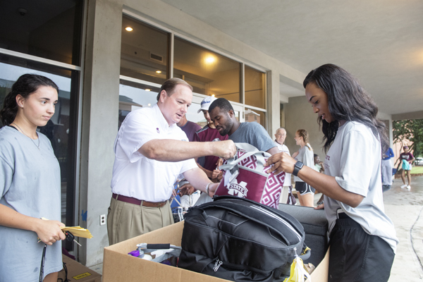 MSU President Mark E. Keenum and Student Association President Mayah Emerson, right, assist students as they move in to MSU