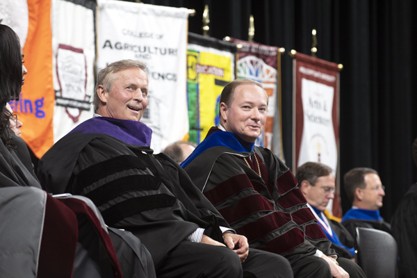 MSU alumnus John Grisham, left, and MSU President Mark E. Keenum smile at the audience during the  university’s Fall Convocation