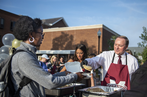 MSU President Mark E. Keenum serves pancakes to students outside of Colvard Student Union