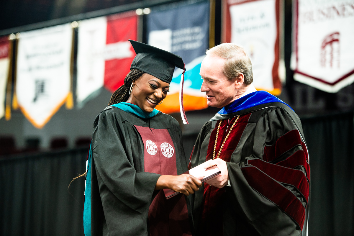 Dr. Keenum congratulates a student crossing the stage at the 2022 Fall commencement exercise.