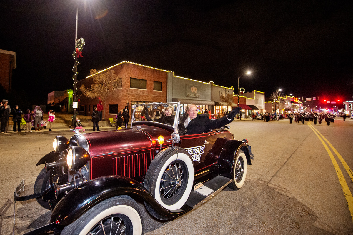 Driving the Cowbell Cruiser, President Keenum and Mayor Lynn Spruill lead Starkville Christmas Parade down Main Street..