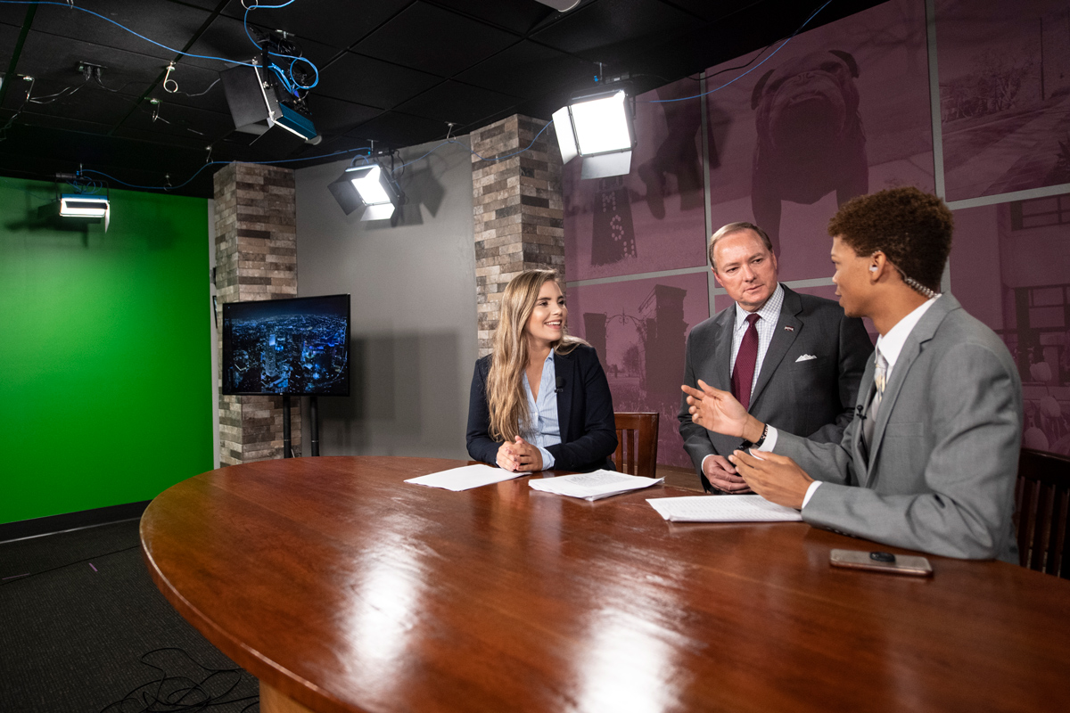 MSU President Mark E. Keenum, center, visits with Rebekah Foxx and Richard Hill news anchors for the Take 30 News program. 