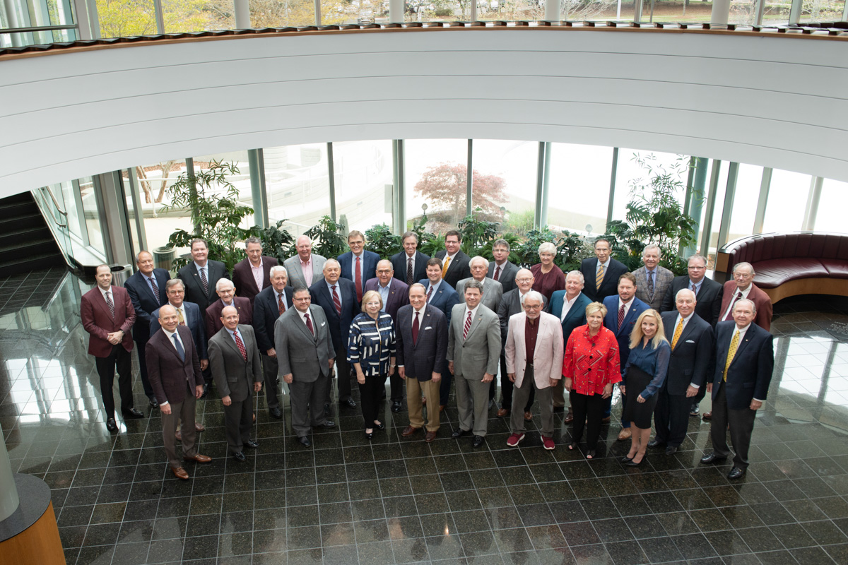 Group photo of MSU's Foundation Board of Directors, standing on the floor of the Hunter Henry Center atrium and looking up.