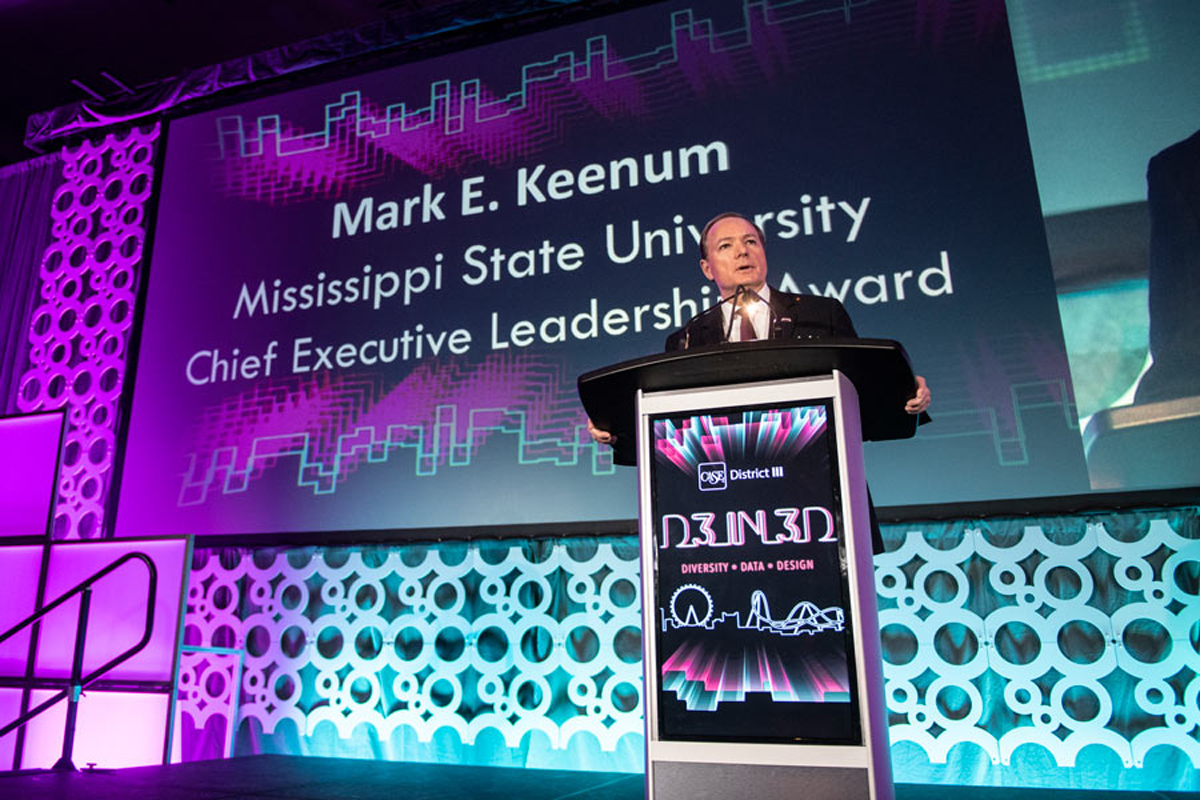 President Keenum speaks from the CASE podium, with the screen behind announcing his award for Chief Executive Leadership.
