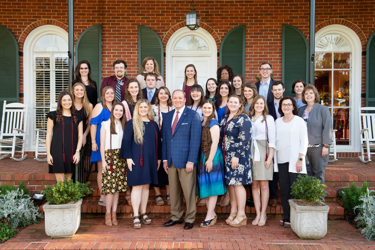 A group of 18 graduating seniors participating in the METP program pose with President Keenum and College of Education staff.