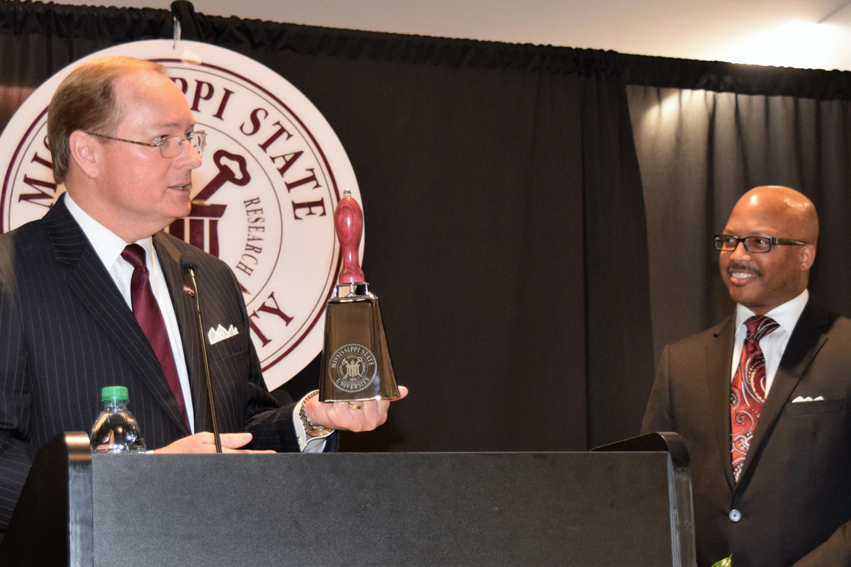 President Keenum presents a cowbell to the Unity Breakfast speaker. 