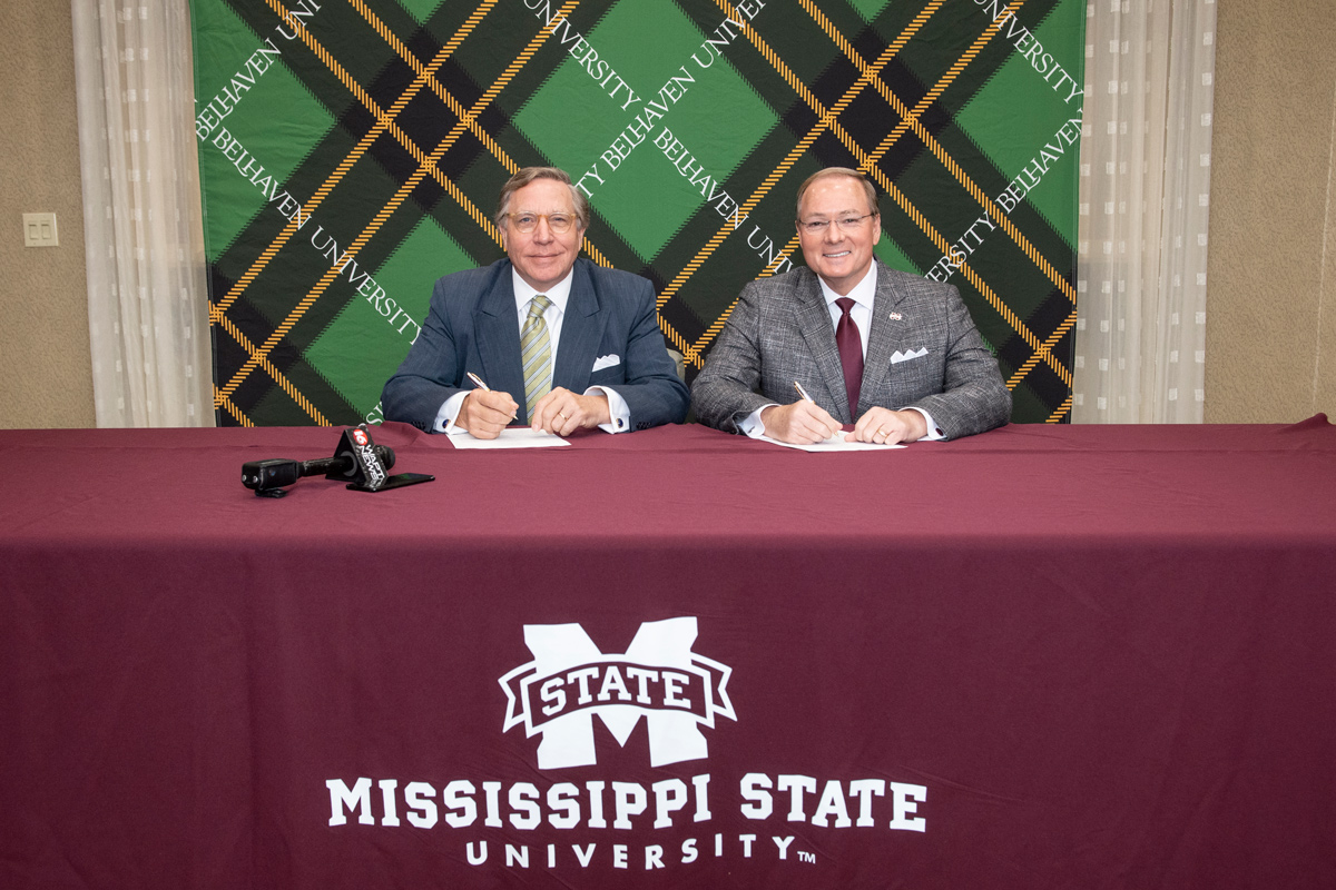 Belhaven University President Roger Parrott, left, and Mississippi State President Mark E. Keenum sign an MOU. 