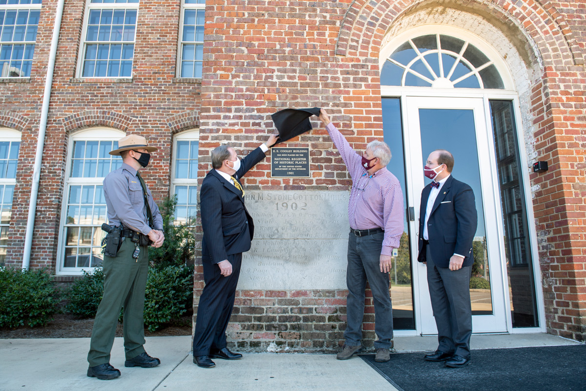 As part of the unveiling of the Mill's historic plaque, President Keenum and Mark Castleberry lift the black cloth covering.