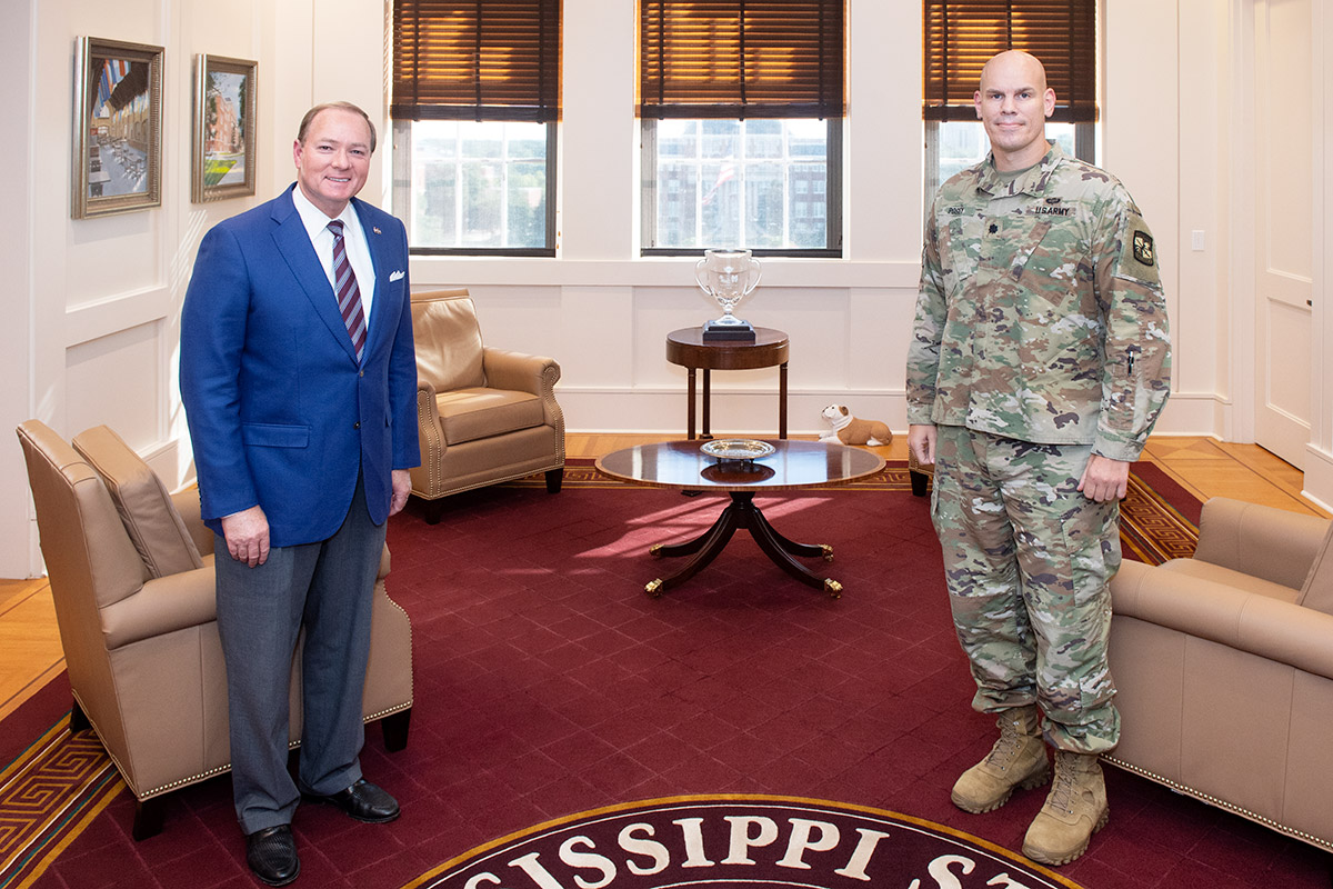 Man in suit and man in military ACU uniform standing in office