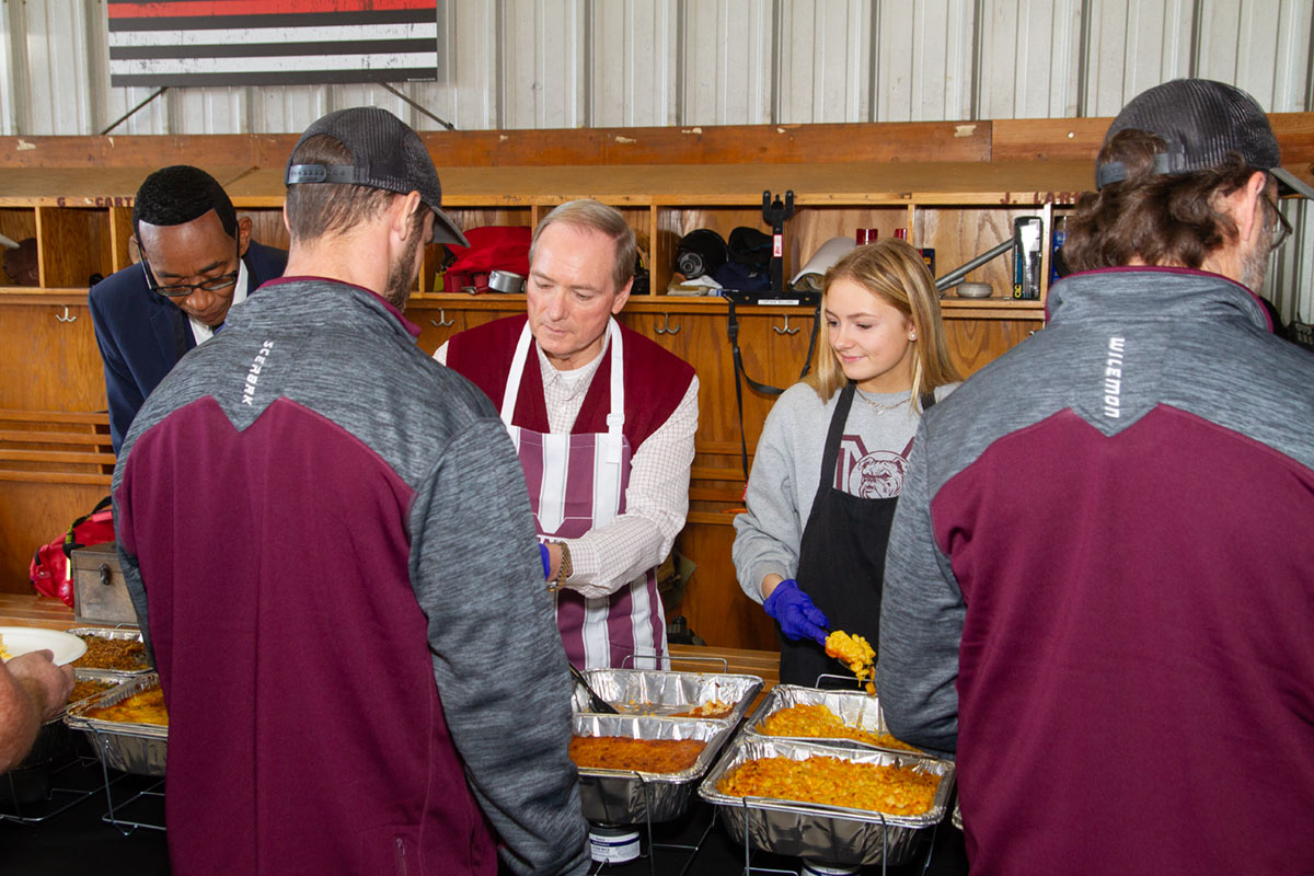 People serving food to first responders in fire station