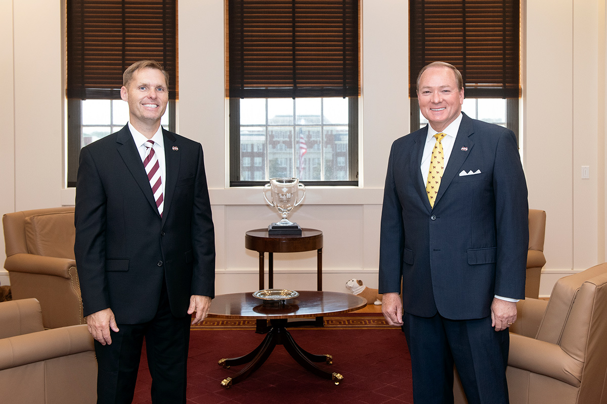 Two men in dark suits standing in office