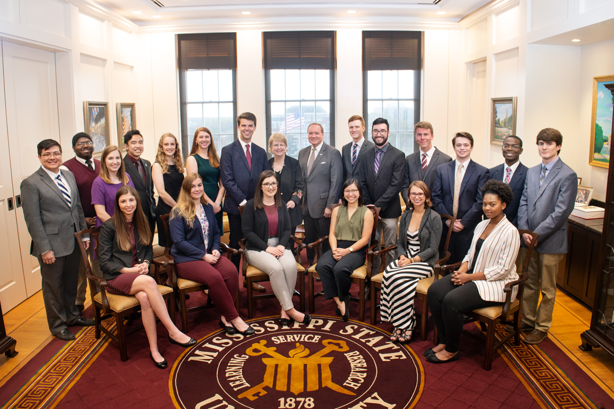 A group of nineteen senior Provost Scholars pose for a photo next to Provost Bonner and President Keenum.