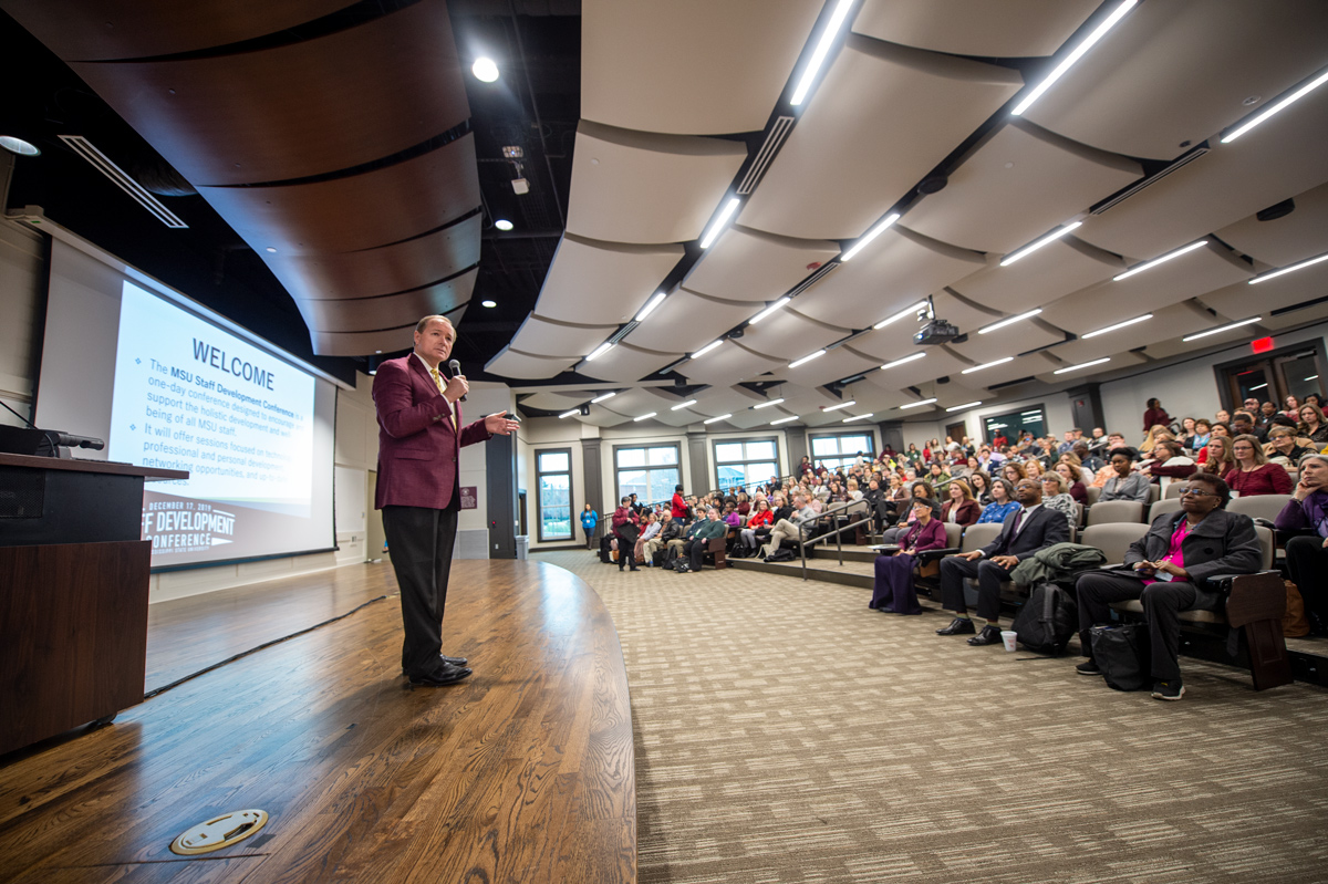 President Keenum speaks on the stage of the Turner Wingo Auditorium, with hundreds of MSU staff in the audience.