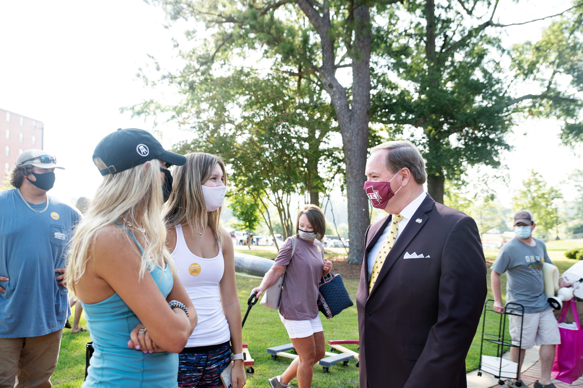 Masked President Keenum speaks to masked arriving students outside Magnolia Hall on Move-In Day 2020.