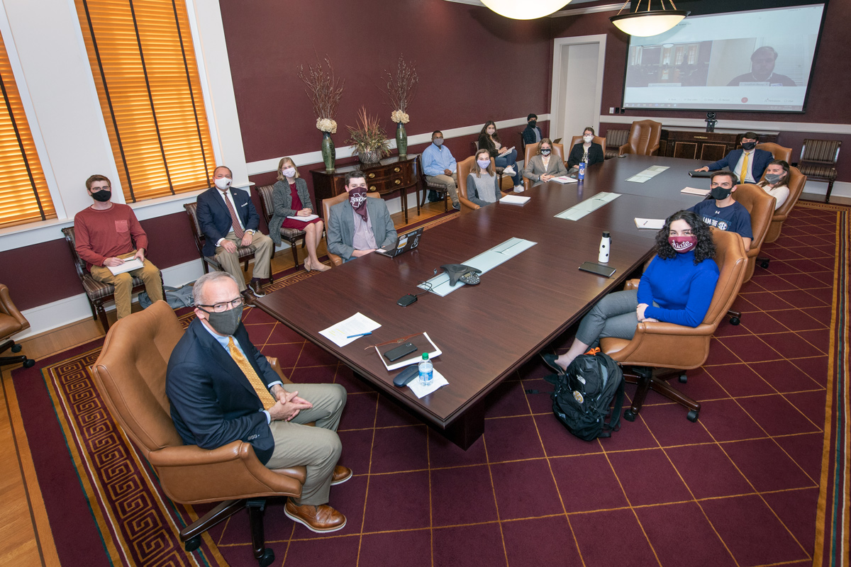 SEC Commissioner Greg Sankey sits at the end of the Presidential table, with masked students in the Leadership class seated.