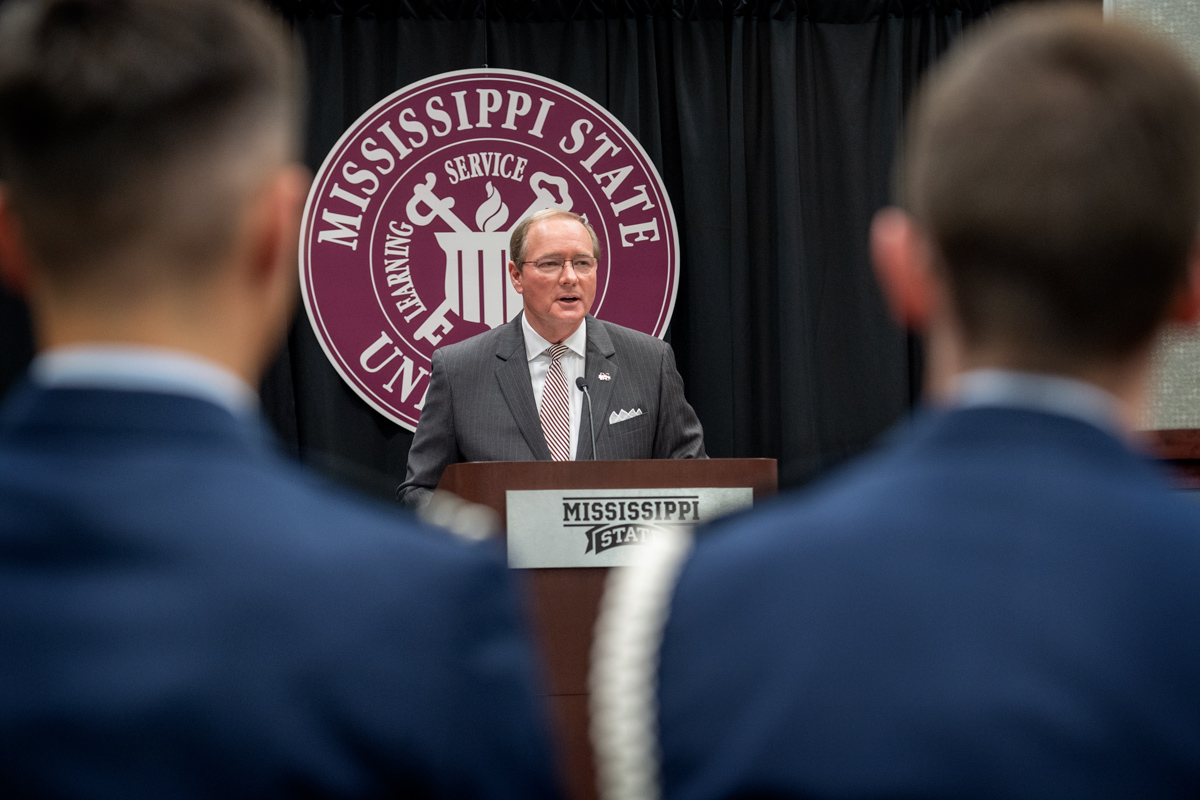 Framed on either side by the heads of cadets in attendance, President Keenum speaks from the podium with the MSU seal behind him