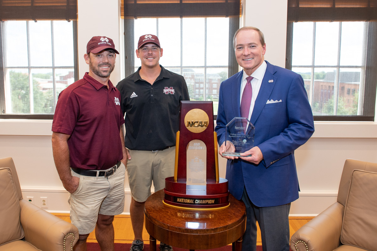 Holding the 2021 Sports Turf award, Keenum stands with MSU Sports Turf aspecialists Brandon Hardin, left, and Todd Hughes. 